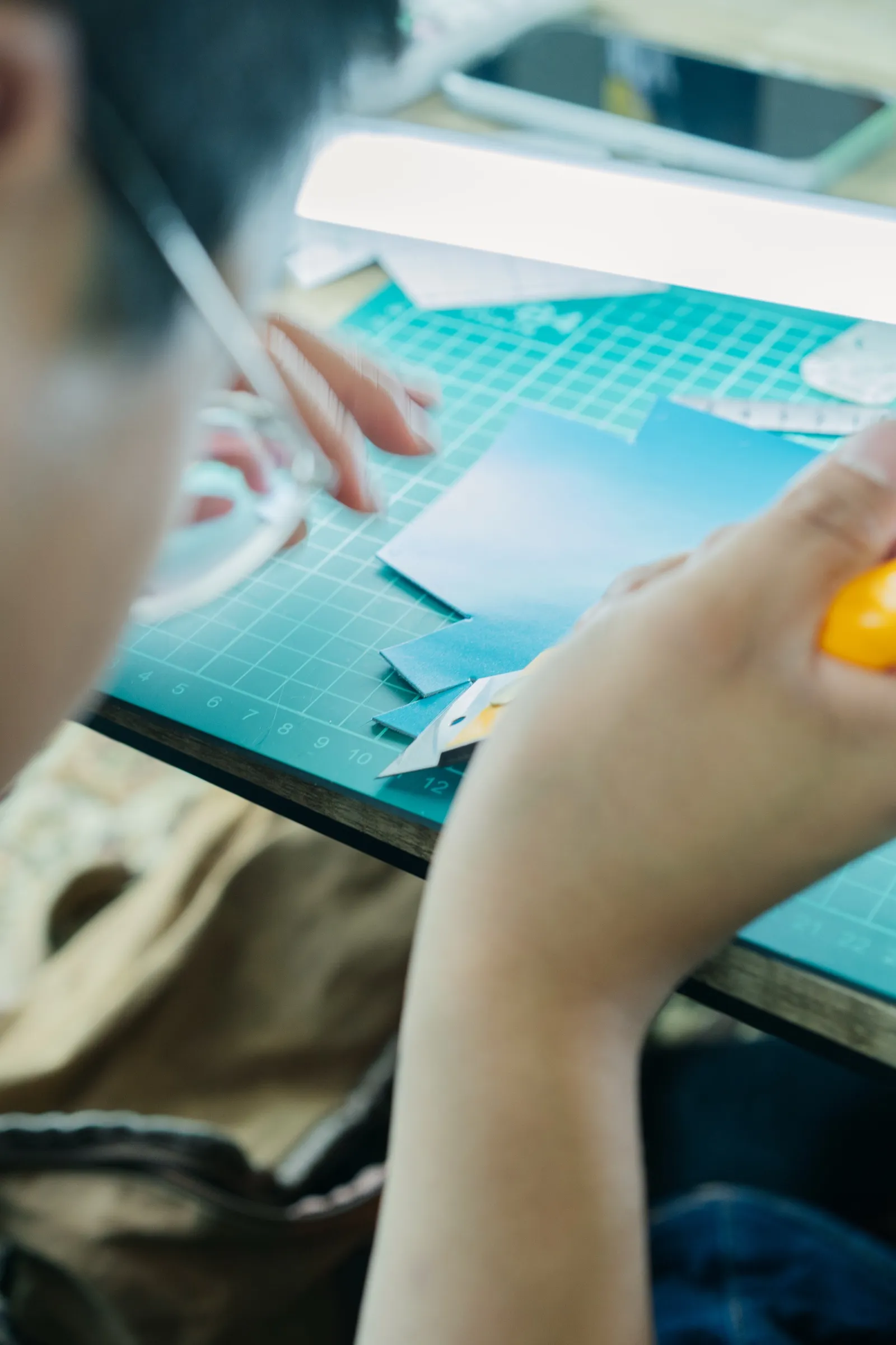カッターマットの上で、革を手で扱っている様子